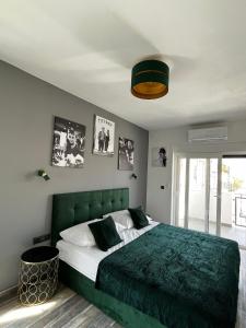 沃迪切LuxVilla AURORA的一间卧室配有一张带绿色床头板的床