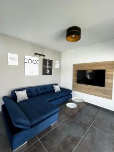 沃迪切LuxVilla AURORA的客厅配有蓝色的沙发和电视