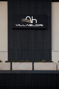 布雷西亚Ah Villaglori Boutique Apartments的植物建筑的一侧的标志