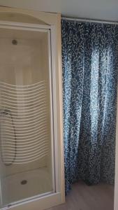 Biville-sur-MerBienvenue chez Anaïs !的玻璃淋浴间,带蓝色和白色窗帘
