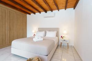 伊兹拉Villa Maria - Hydra Dream Houses的卧室设有白色的床和木制天花板。