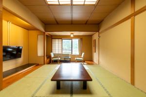 大崎市Ooedo Onsen Monogatari Kounkaku的客厅配有桌子和电视