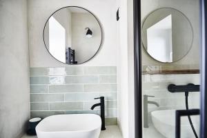 乌尔加特Maison normande face à la plage d'Houlgate的浴室设有两面镜子、一个卫生间和一个盥洗盆