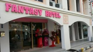马六甲范特西酒店的大楼前有粉红色标志的商店