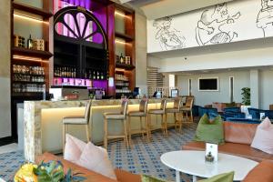 约翰内斯堡Piazza Hotel Montecasino的餐厅内的酒吧配有椅子和柜台