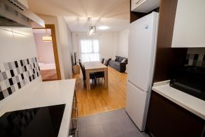 卡斯特利翁-德拉普拉纳Castellon Ribalta Apartments - Parking disponible的厨房以及带桌子和冰箱的客厅。