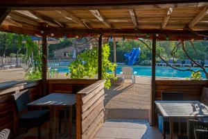莱塞齐耶德泰阿克Camping Le Pech Charmant的一个带桌椅的庭院和一个游泳池