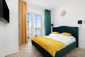 华沙Vola Palace的一间卧室配有一张带黄色毯子的大床