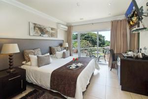 德班uShaka Manor Guest House的一间卧室配有一张床、一张书桌和一个窗户。