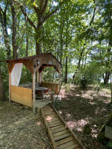 MiélanHebergement insolite, Location Yourte au bord du lac de mielan的森林中间的小小屋