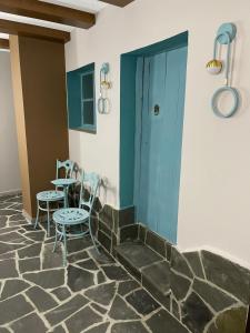 吉诺卡斯特Palorto Hotel的配有桌椅和蓝色门的房间