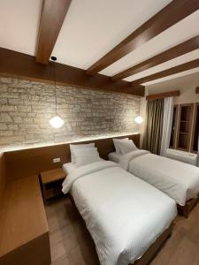 吉诺卡斯特Palorto Hotel的砖墙客房的两张床