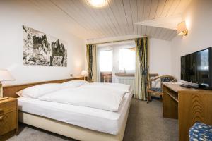塞斯托瓦尔德海姆酒店的卧室配有白色的床和电视。