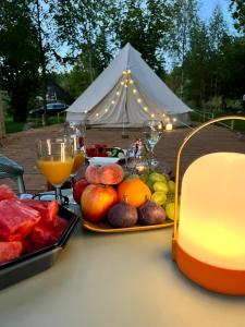 Glamping Žvaigždžių slėnyje的一张带水果和饮料的桌子和一个帐篷