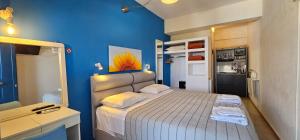 拉瑟玛塔萨图斯公寓的一间小卧室,配有一张床和蓝色的墙壁