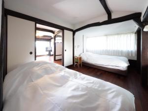 叶山町Hayama Isshiki Beach House -葉山 一色海岸の家 - ペット可的一间带白色床的卧室和一间带窗户的卧室