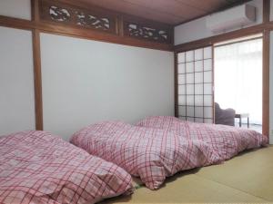 阿苏市Guest House Asora的卧室配有带2个枕头的窗户。
