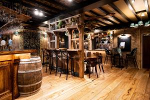 格拉斯米尔The Swan at Grasmere- The Inn Collection Group的一间铺有木地板并配有桌椅的酒吧