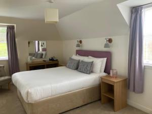 普洛克顿The Haven Guest House的卧室配有一张白色大床和紫色窗帘
