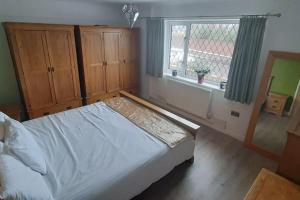 西柯比GOLF OPEN HOYLAKE Bungalow In West Kirby的一间卧室设有一张床和一个窗口