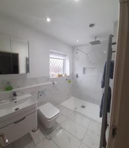 西柯比GOLF OPEN HOYLAKE Bungalow In West Kirby的白色的浴室设有卫生间和水槽。