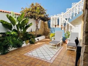 特尔德La Dama del Mar的一座庭院,庭院内摆放着白色椅子和植物