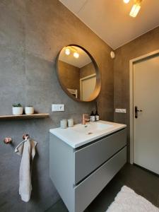 EwijkBohemian Wellness met hottub & sauna的浴室设有白色水槽和镜子