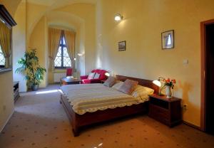 Jirkov泽觅克舍维尼哈拉迪克酒店的一间卧室配有一张床和一个沙发