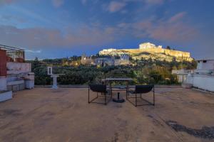 雅典Holodek Apartments : Parthenon的城堡屋顶上的一张桌子和两把椅子
