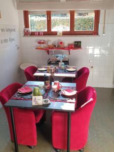 维罗纳阿格利艾塞里住宿加早餐酒店的一间设有红色椅子的桌子和一张带食物的桌子的房间
