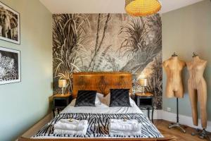 德拉韦伊luxury Villa Marie Emeraude Paris Orly Jacuzzi的一间卧室配有一张床和壁画墙