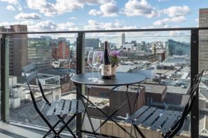 曼彻斯特Church Street by Supercity Aparthotels的阳台上的桌子上摆放着两杯酒和瓶子