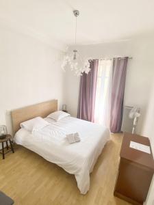 戛纳艾斯佩兰托酒店的卧室配有白色的床和吊灯。