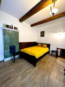 KrzeszowiceMATOGÓWKA的一间卧室设有一张黄色的床和一个壁炉