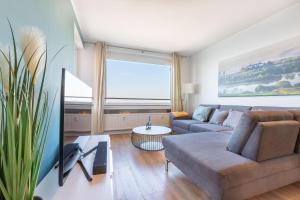 布隆MOOI: Fantastisches Apartment mit Seeblick und Stil, Netflix的客厅配有沙发和桌子