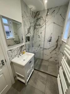 伯恩茅斯Beach Lodge的白色的浴室设有水槽和淋浴。
