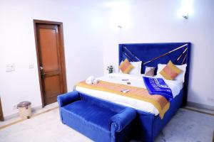 新德里Fortune Home Service Apartment 1bhk, D-198,UGF的一张大床,在房间内有一个蓝色床头板