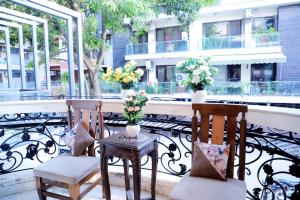 新德里Fortune Home Service Apartment 1bhk, D-198,UGF的阳台上配有两把椅子和一张带鲜花的桌子