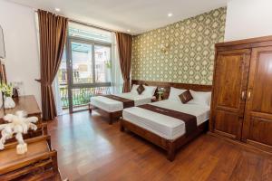 大叻Villa Bảo Anh Dalat的一间卧室设有两张床和大窗户