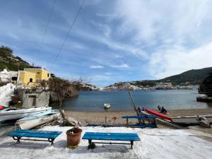 蓬扎Camere Dieci Maggio的海滩上设有三个蓝色长椅和船只