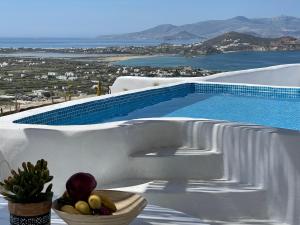 纳克索乔拉Eye of Naxos的游泳池畔的桌子上放上一碗水果