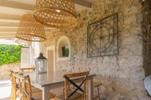 凯玛丽Pintor - Rustic Mallorquin town house 3 bedrooms and pool in Caimari的用餐室设有石墙、桌子和椅子