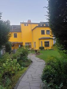 柏林Miet-Kamp ruhig, zentral, nahe Messe, ausgefallenes design 2 Schlafzimmer的前面有一条石头路的黄色房子