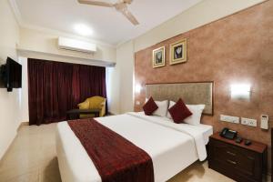 浦那7 Apple Hotel Pimpri Pune的酒店客房,配有床和电视