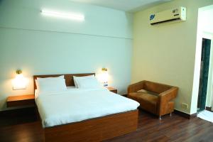 孟买Country Inn & Suites By Turtle的一间卧室配有一张大床和一把椅子