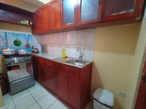 万卡约Departamento cerca al centro de Huancayo.的一个带红色橱柜和水槽的小厨房