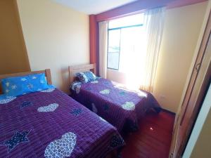 万卡约Departamento cerca al centro de Huancayo.的一间卧室设有两张床和窗户。