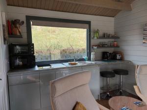 BracadaleCROFTERS CABIN的厨房设有窗户和带微波炉的台面