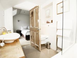 洛亨黑德莫纳齐尔莫霍酒店的浴室设有开放式门、水槽和床。