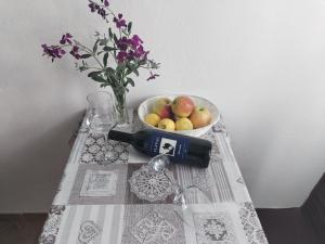 波拉斯Apartments Patricija的一张桌子,上面放着一碗水果和一瓶葡萄酒